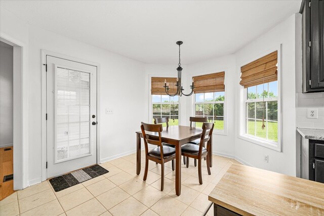 dining room featuring light tile patterned floors, a chandelier, and baseboards