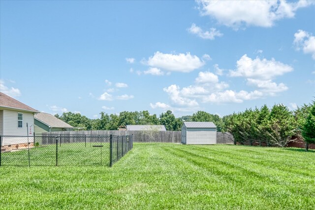 view of yard with an outbuilding, a shed, and a fenced backyard