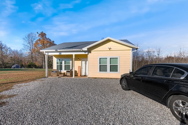 bungalow-style house with a front yard, covered porch, and metal roof