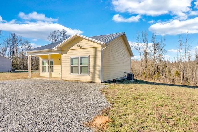 exterior space with central AC unit and a front yard