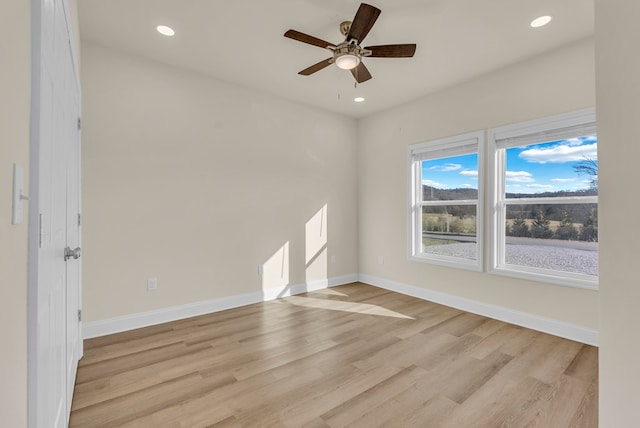 spare room featuring light wood finished floors, ceiling fan, baseboards, and recessed lighting