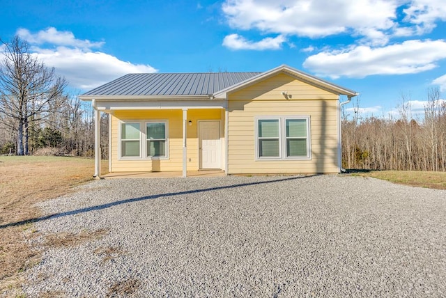 view of front of property featuring gravel driveway and metal roof