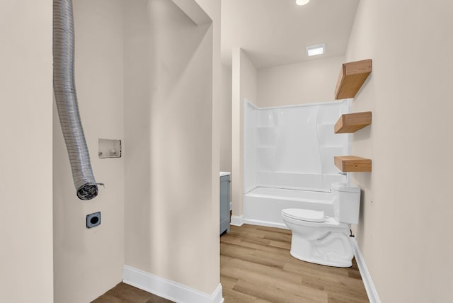 full bathroom featuring toilet, baseboards, wood finished floors, and shower / bathing tub combination