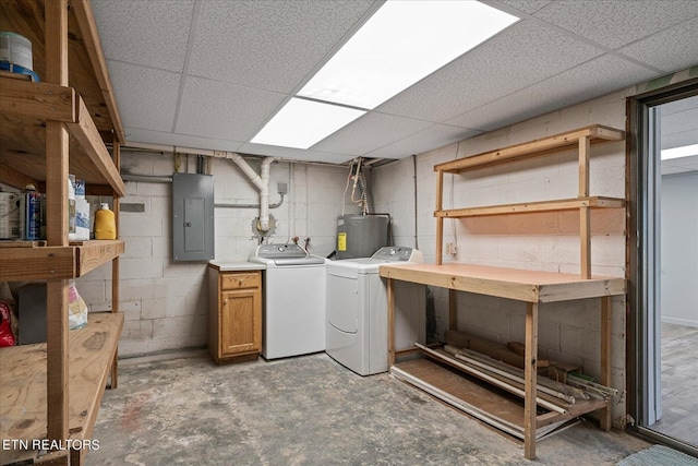 finished basement with washer and dryer, electric panel, concrete block wall, and electric water heater