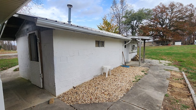 view of side of property featuring metal roof, a yard, and stucco siding