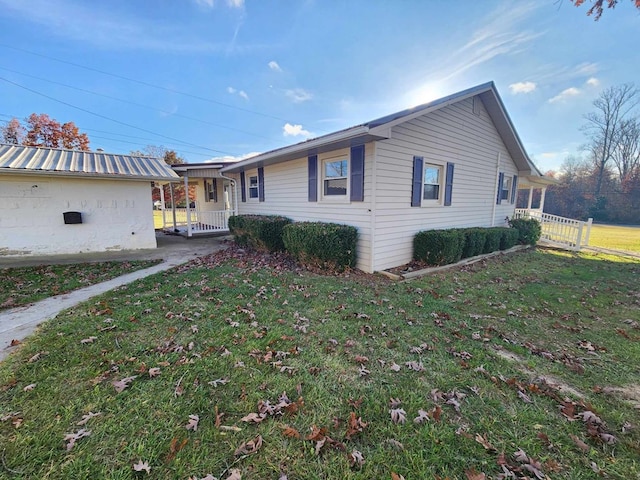 view of side of home featuring a porch and a lawn