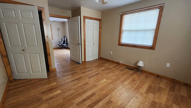 unfurnished bedroom featuring light wood-type flooring, visible vents, and baseboards