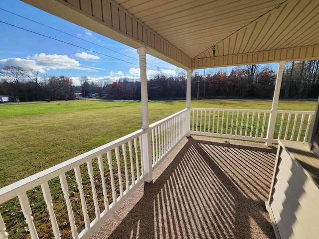 wooden deck with a porch and a lawn