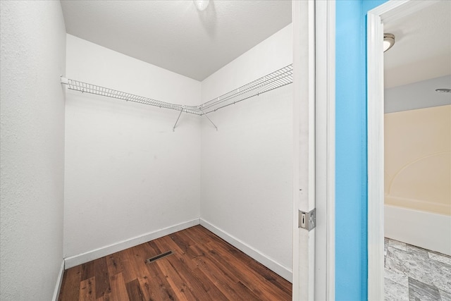 walk in closet with visible vents and wood finished floors