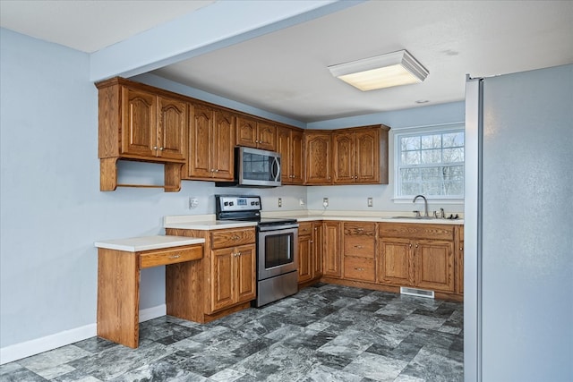 kitchen with brown cabinets, stainless steel appliances, and a sink