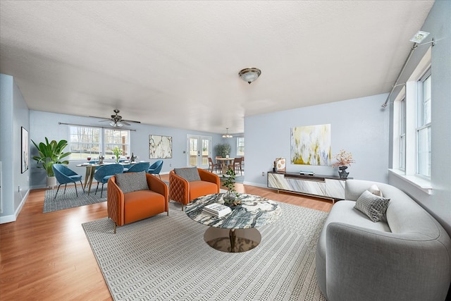 living area with light wood-type flooring, plenty of natural light, and baseboards