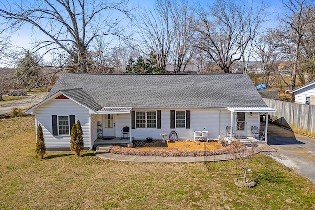 ranch-style home featuring a porch, a shingled roof, fence, driveway, and a front yard