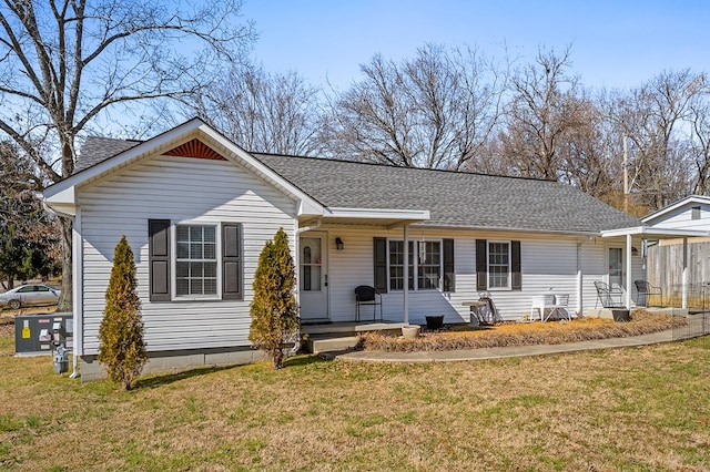 ranch-style house with covered porch, a shingled roof, and a front yard