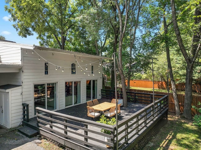 rear view of house featuring fence and a wooden deck