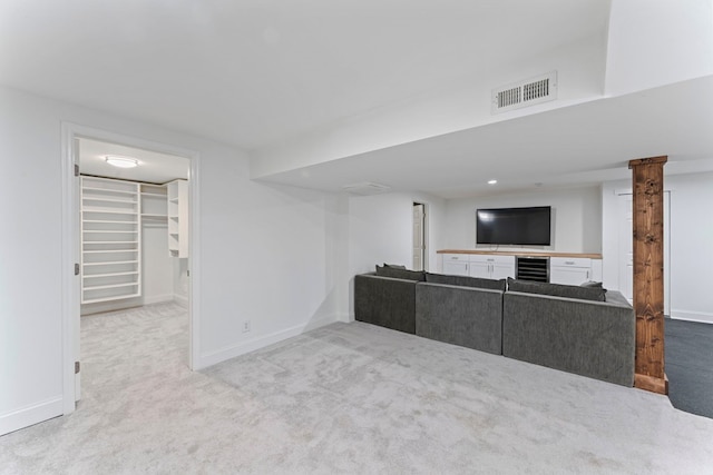 living area with light colored carpet, visible vents, baseboards, and wine cooler