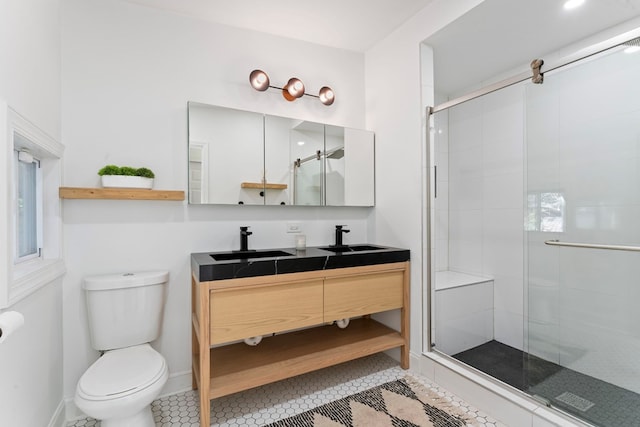 bathroom featuring a stall shower, a sink, toilet, and tile patterned floors