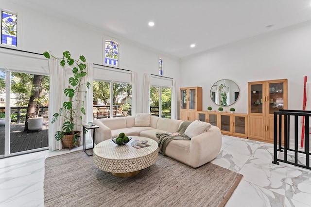 living room with recessed lighting, marble finish floor, crown molding, and a towering ceiling