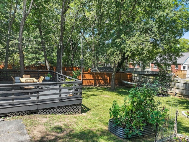 view of yard with a fenced backyard, a vegetable garden, and a deck