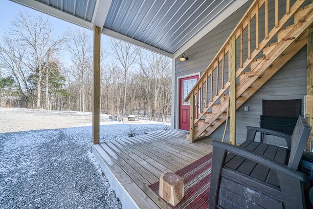 snow covered deck featuring stairs