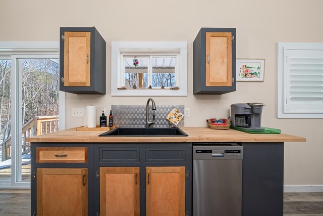 bar featuring dishwasher, wood finished floors, a sink, and baseboards