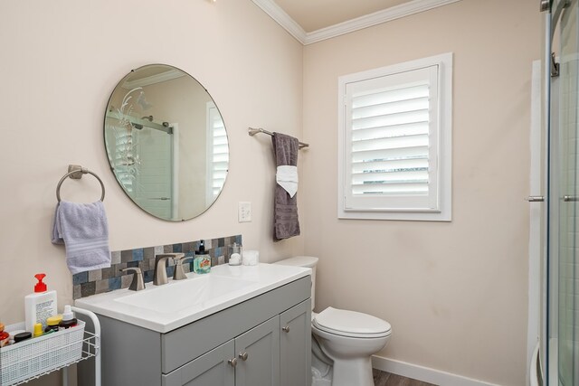 bathroom featuring crown molding, vanity, toilet, and an enclosed shower