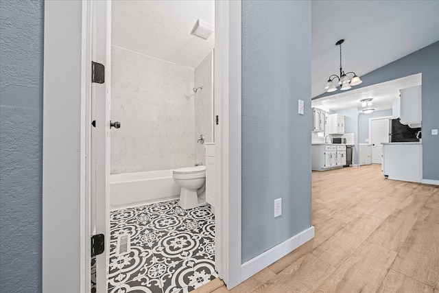 bathroom with toilet, bathing tub / shower combination, baseboards, and wood finished floors