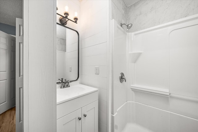 full bathroom with a shower, vanity, and a textured ceiling