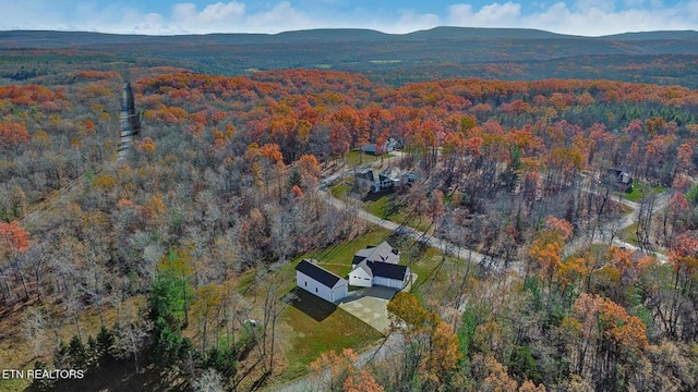 drone / aerial view with a wooded view and a mountain view