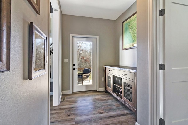 doorway featuring dark wood finished floors and baseboards