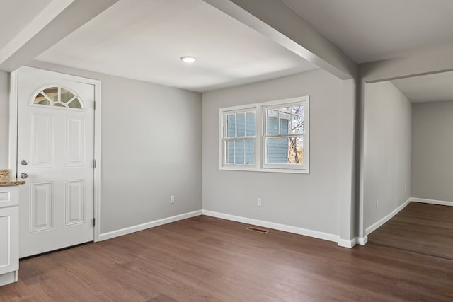 foyer featuring wood finished floors, visible vents, and baseboards