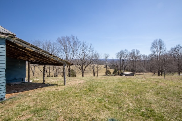 view of yard with a carport and a rural view