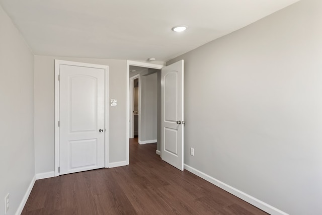 unfurnished bedroom with dark wood-style floors and baseboards