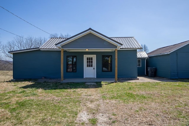 view of front of home featuring a porch, a front lawn, and metal roof