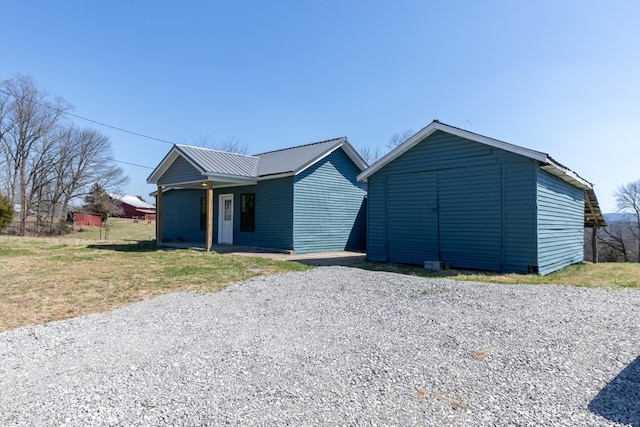 view of front of house with an outbuilding, a shed, and metal roof