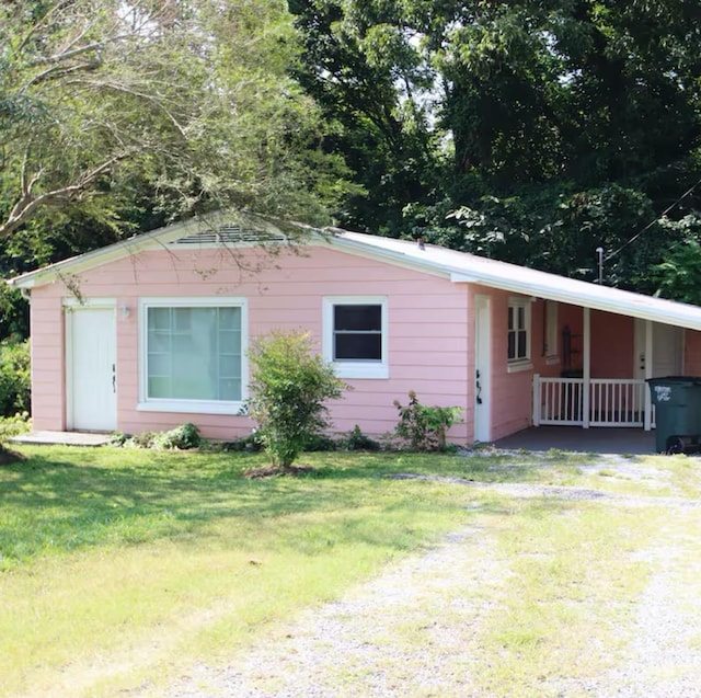 ranch-style house with driveway, a front lawn, and an attached carport