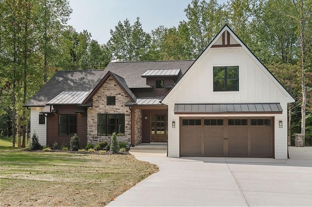 modern farmhouse style home with metal roof, concrete driveway, board and batten siding, a standing seam roof, and a front yard