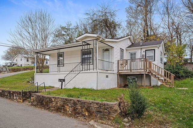 view of front of property featuring covered porch, stairway, and a front lawn