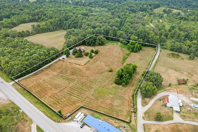 birds eye view of property featuring a forest view and a rural view