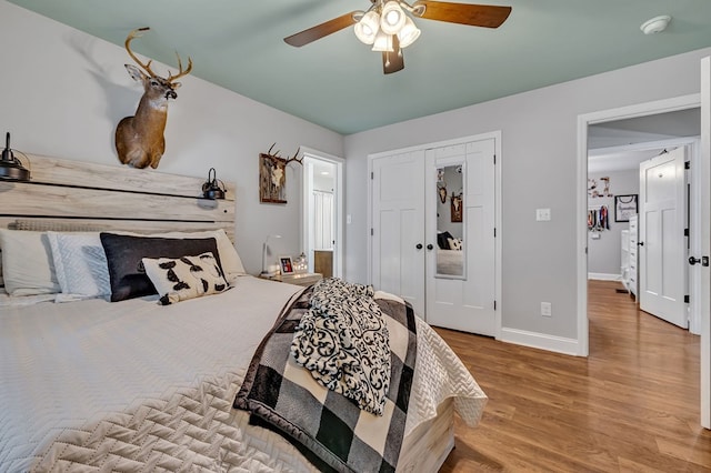 bedroom featuring light wood-style floors, a closet, baseboards, and a ceiling fan