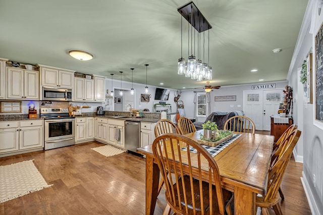 dining room with light wood-type flooring, baseboards, a ceiling fan, and ornamental molding