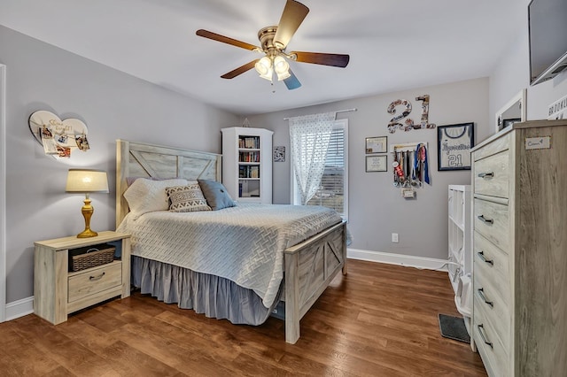 bedroom featuring wood finished floors, a ceiling fan, and baseboards