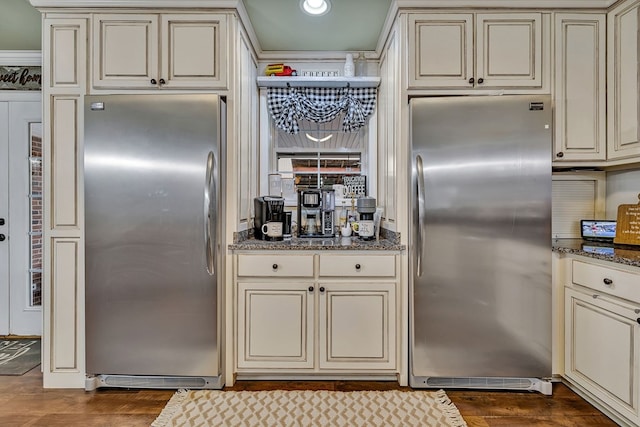 kitchen with cream cabinets, stainless steel refrigerator, and freestanding refrigerator