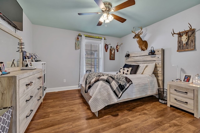 bedroom featuring dark wood-type flooring, baseboards, and a ceiling fan