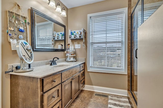 bathroom with vanity, a shower stall, visible vents, and baseboards