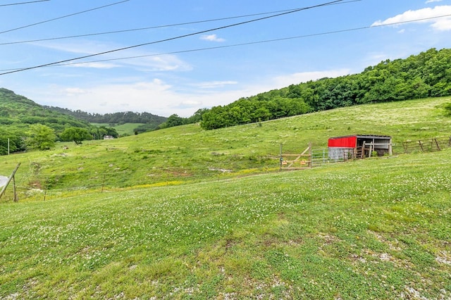 view of yard featuring a pole building, a rural view, and fence