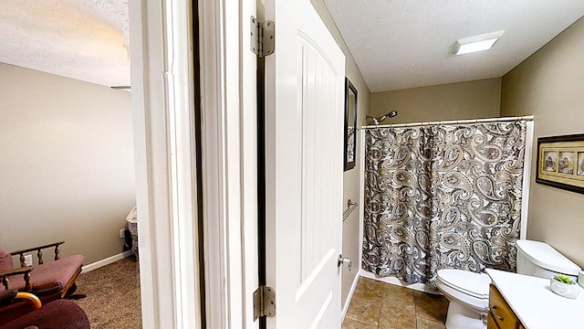 full bathroom with a textured ceiling, toilet, and vanity