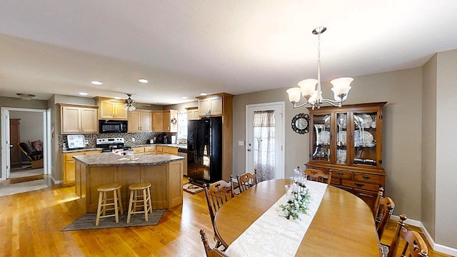 dining space featuring baseboards, ceiling fan with notable chandelier, recessed lighting, and light wood-style floors