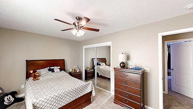 bedroom featuring a closet, light colored carpet, ceiling fan, and a textured ceiling