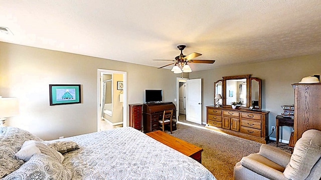 bedroom featuring a textured ceiling, carpet flooring, visible vents, a ceiling fan, and ensuite bath