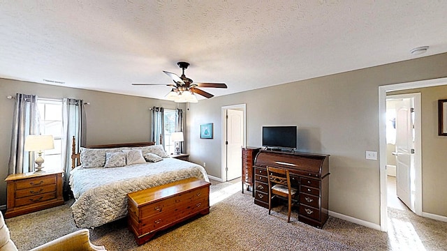 bedroom with visible vents, baseboards, a ceiling fan, a textured ceiling, and carpet flooring